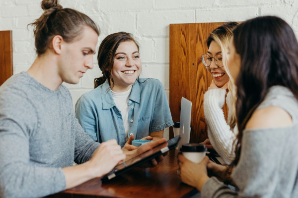 A group of friends gathered together at a coffee shop, talking and socialising.