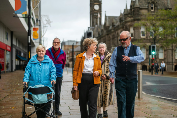 A group of seniors walking together down a city street.