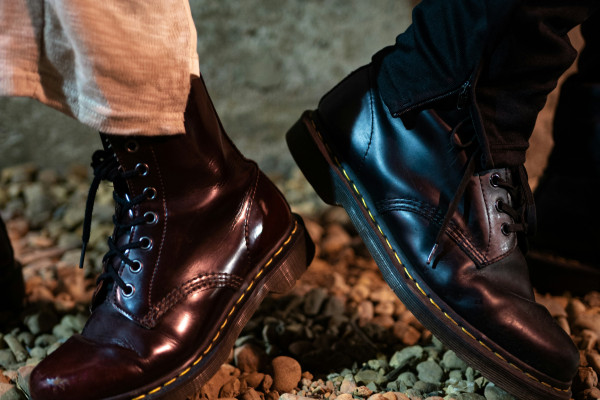 A close-up of a well-worn pair of boots on a rocky path.