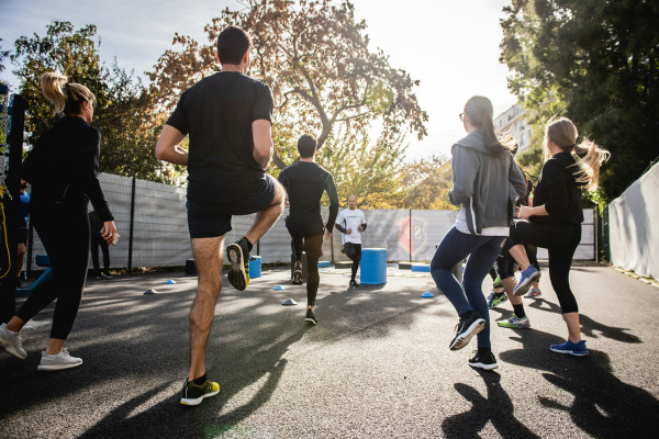 A man runs along a road in daylight, representing active, ongoing health rather than waiting for pain to strike.