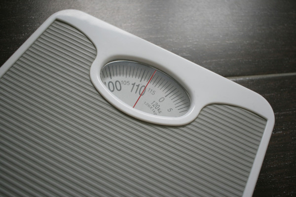 A bathroom scale sitting on top of a wooden table.