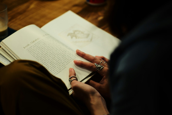 Someone relaxing at home while reading a book, one of the simple hobbies that can help calm the nervous system