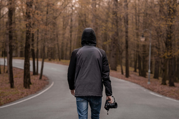 A man walking along a road, showing the full-body rotational movement involved in a normal walking gait