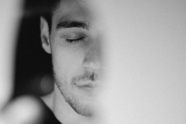 A man looking at his own reflection in a mirror.