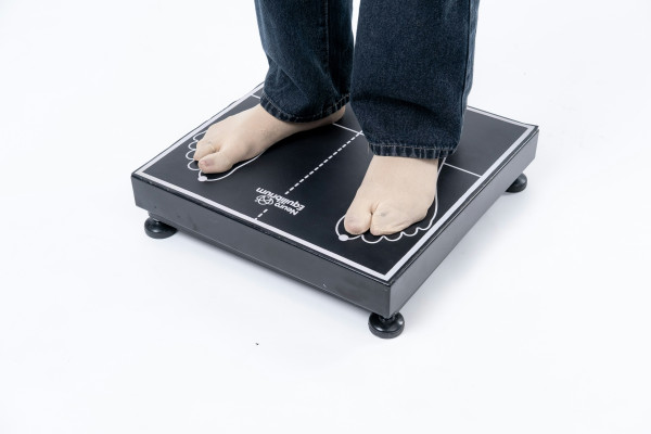 A close-up of a person's feet on a digital balance and stability assessment platform, used to evaluate coordination and alignment.