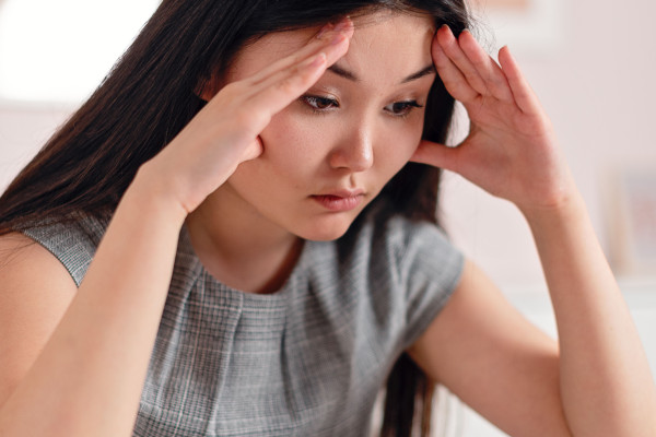 Photo of a stressed woman with her hands on her head