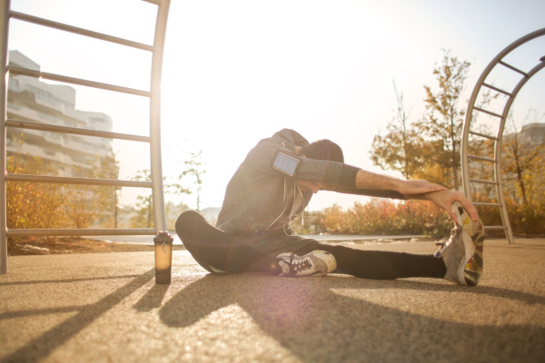 Man stretching outdoors at sunrise as part of a morning fitness routine