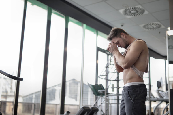 Sweaty, tired man resting after an intense workout in a gym