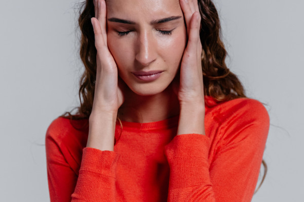 Woman holding her head in discomfort during a headache