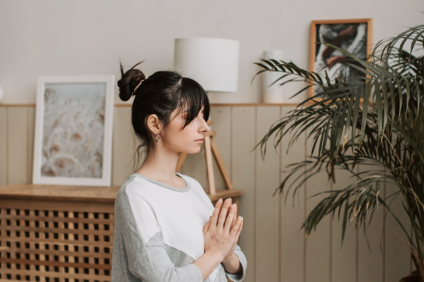 Woman meditating peacefully in a calm, softly lit indoor setting