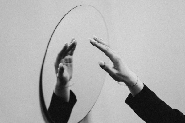 A person standing quietly, seen from behind, in a moment of reflection.