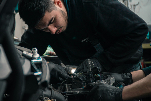 A mechanic performing maintenance work on a car engine.